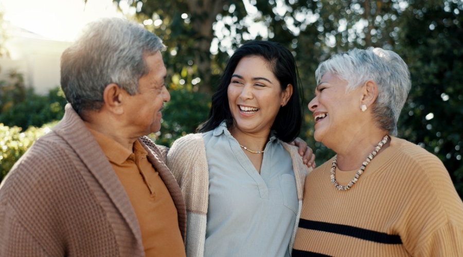 Elder couple laughing with doctor outside